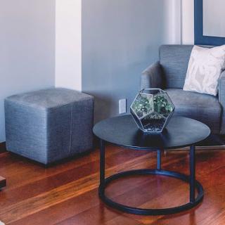 A cozy modern living room setup featuring a stylish sofa, an ottoman, and a sleek coffee table.