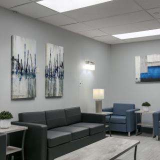 A modern waiting room featuring stylish furniture and contemporary artwork.