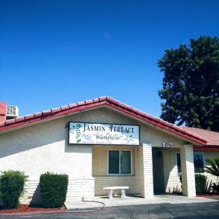 Exterior view of a small restaurant with a red roof under a clear blue sky.