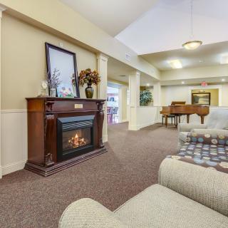 A cozy living room with a fireplace and a grand piano.