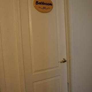 A closed door with a bedroom sign attached.