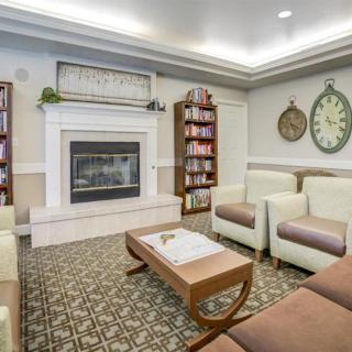 A cozy living room featuring a fireplace, bookshelves, and comfortable seating.