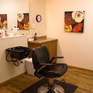 A hair salon interior with a styling chair and mirror.
