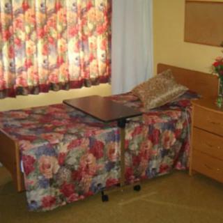 A cozy bedroom with floral-patterned bedding and curtains.
