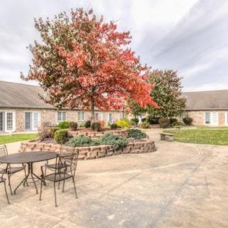 A peaceful courtyard with autumn trees and patio seating.