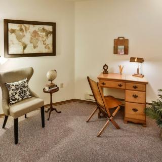A cozy home office space featuring a wooden desk, comfortable chairs, and stylish decor.