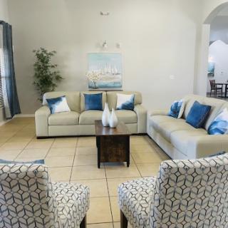 A cozy living room featuring modern furniture with blue accents and decorative artwork.