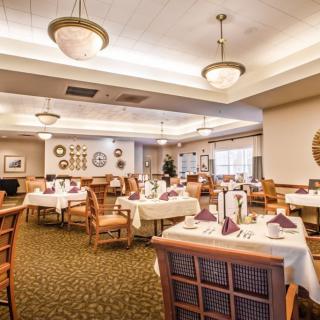 A spacious and elegantly decorated restaurant dining area with neatly arranged tables and chairs.