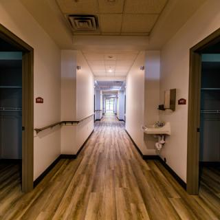 A well-lit hallway with multiple doors leading to different rooms.