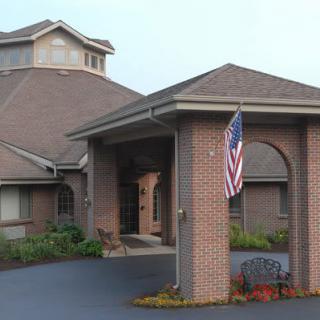 A brick building with an entrance featuring an American flag.