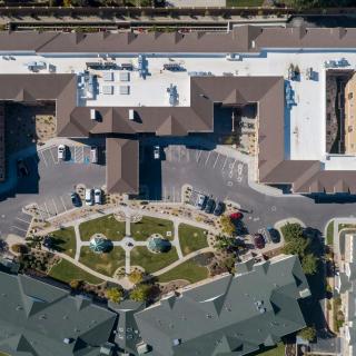 An aerial view of a large building complex featuring a central courtyard with landscaped gardens.