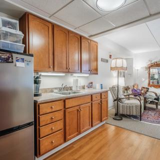 A well-equipped kitchen featuring wooden cabinets and modern appliances, showcasing a cozy interior design.