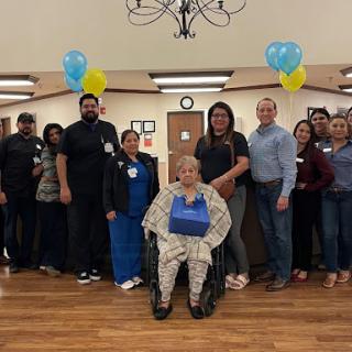 A joyful celebration with staff and residents at a senior care facility.