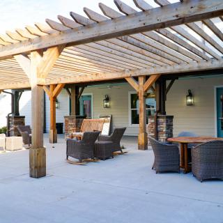 Spacious patio with a wooden pergola and comfortable outdoor seating.
