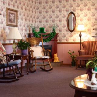 A cozy living room featuring a mix of classic furniture and decorative plants, creating a warm and inviting atmosphere.