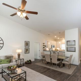 A modern open-concept living and dining area featuring neutral tones and sleek furnishings.