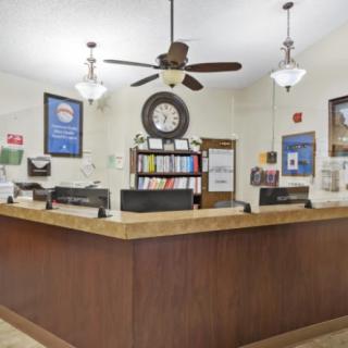 A welcoming reception desk area with a ceiling fan and clock.