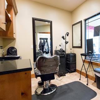 A cozy hair salon space featuring a stylish barber chair and essential tools for hair styling.