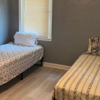 A minimalist bedroom with two twin beds and simple decor.