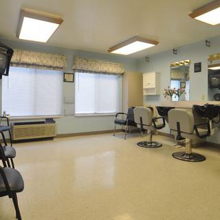 A well-lit salon interior with styling chairs and a waiting area.