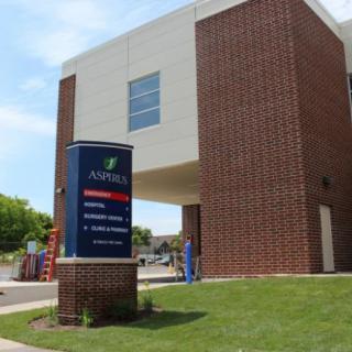 A modern hospital building with a prominent entrance and signage.