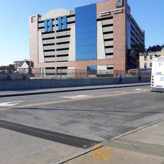 A view of a modern parking garage in an urban setting under a clear blue sky.