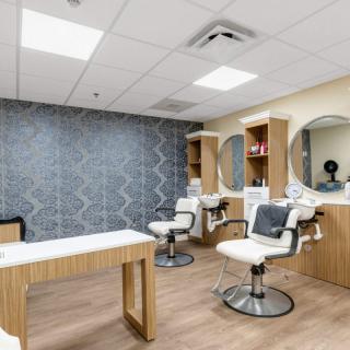 A modern beauty salon interior with styling chairs and mirrors.