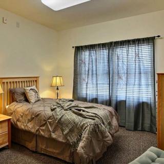 A cozy bedroom with a large bed, wooden furniture, and soft lighting.