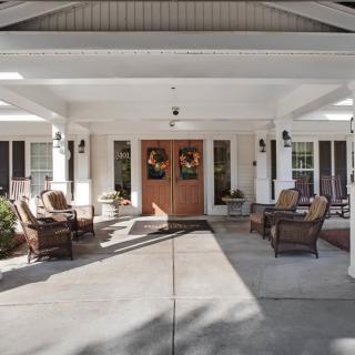 A cozy front porch with comfortable seating and fall-themed decorations.
