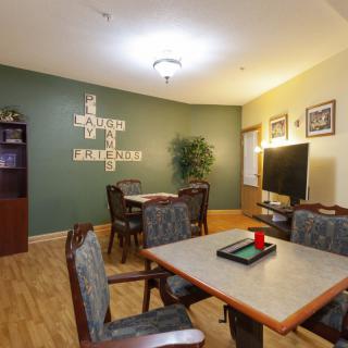 A cozy living area with dining tables, a TV, and decorative elements.