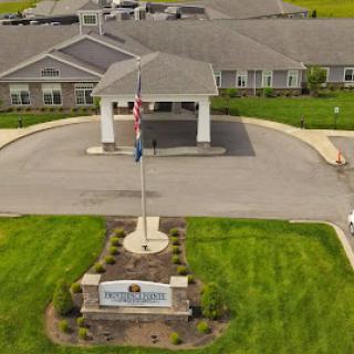 Aerial view of a welcoming entrance to a residential building with well-maintained landscaping.