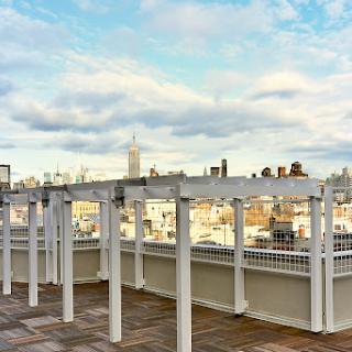 A serene rooftop view showcasing a city skyline under a partly cloudy sky.