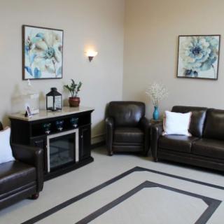 A cozy living room with leather furniture and decorative artwork on the walls.