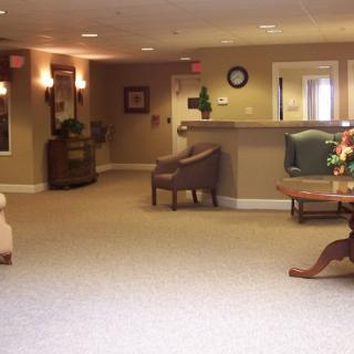 A spacious and warmly decorated lobby area with seating and a reception desk.