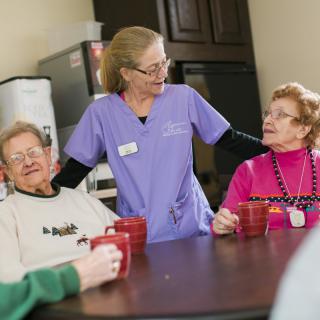 A caregiver interacting with elderly people at a senior care facility, fostering a warm and friendly environment.