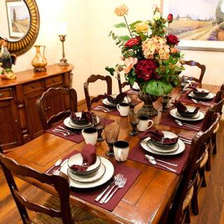 An elegantly set dining table adorned with flowers and complete dishware.
