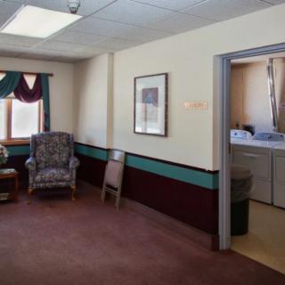 A cozy living area featuring a chair, window, and adjacent bathroom.