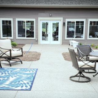 A cozy outdoor patio area with seating and a decorative rug.