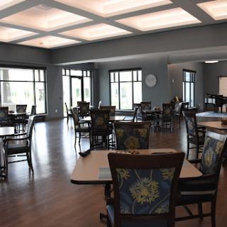 A spacious and well-lit dining area featuring modern furniture, suitable for community gatherings.