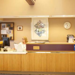 A receptionist working at a reception desk in an office setting.