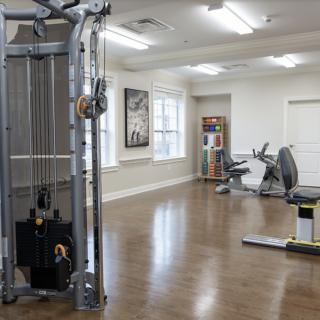 A clean and spacious gym with various exercise machines and fitness equipment.