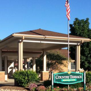 Entrance to a building with an American flag and a sign that reads 'Country Terrace'.