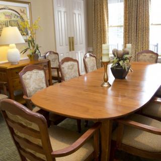 A well-furnished dining room featuring a wooden table with chairs and elegant decor.