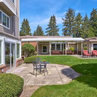 A spacious backyard patio with outdoor seating and a well-maintained lawn.