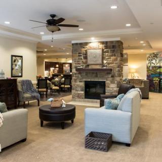 A cozy living room with comfortable seating and a stone fireplace.
