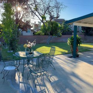 A sunny backyard with a patio set and lush greenery.