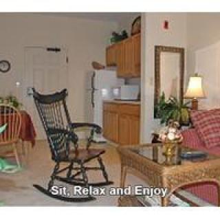 A cozy living area with a rocking chair and kitchenette, inviting you to sit, relax, and enjoy.
