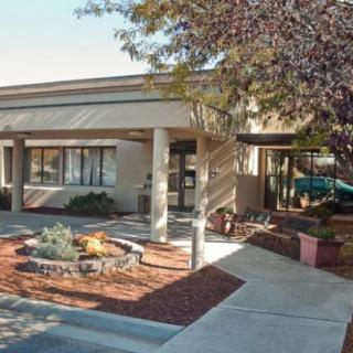 A building entrance with landscaping and trees in front, captured during the daytime.
