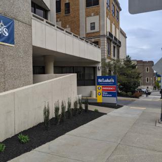 A view of a modern building entrance with signage in an urban setting.