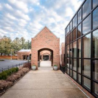 A serene pathway framed by brick architecture and modern glass facades.